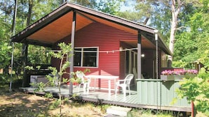 A small, single-story cabin with a porch, a table, and chairs.