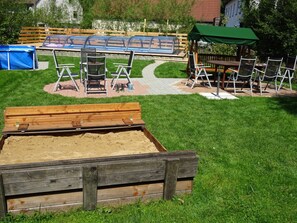 A playground with swings, a sandbox, and a covered seating area. - Three Peaks - Ferienhof High (Hiltpoltstein)