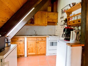 Una cocina con armarios de madera, una estufa blanca y una cafetera.