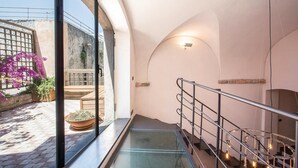 Un intérieur moderne avec un escalier en verre, une vue sur l’espace extérieur et un design minimaliste.