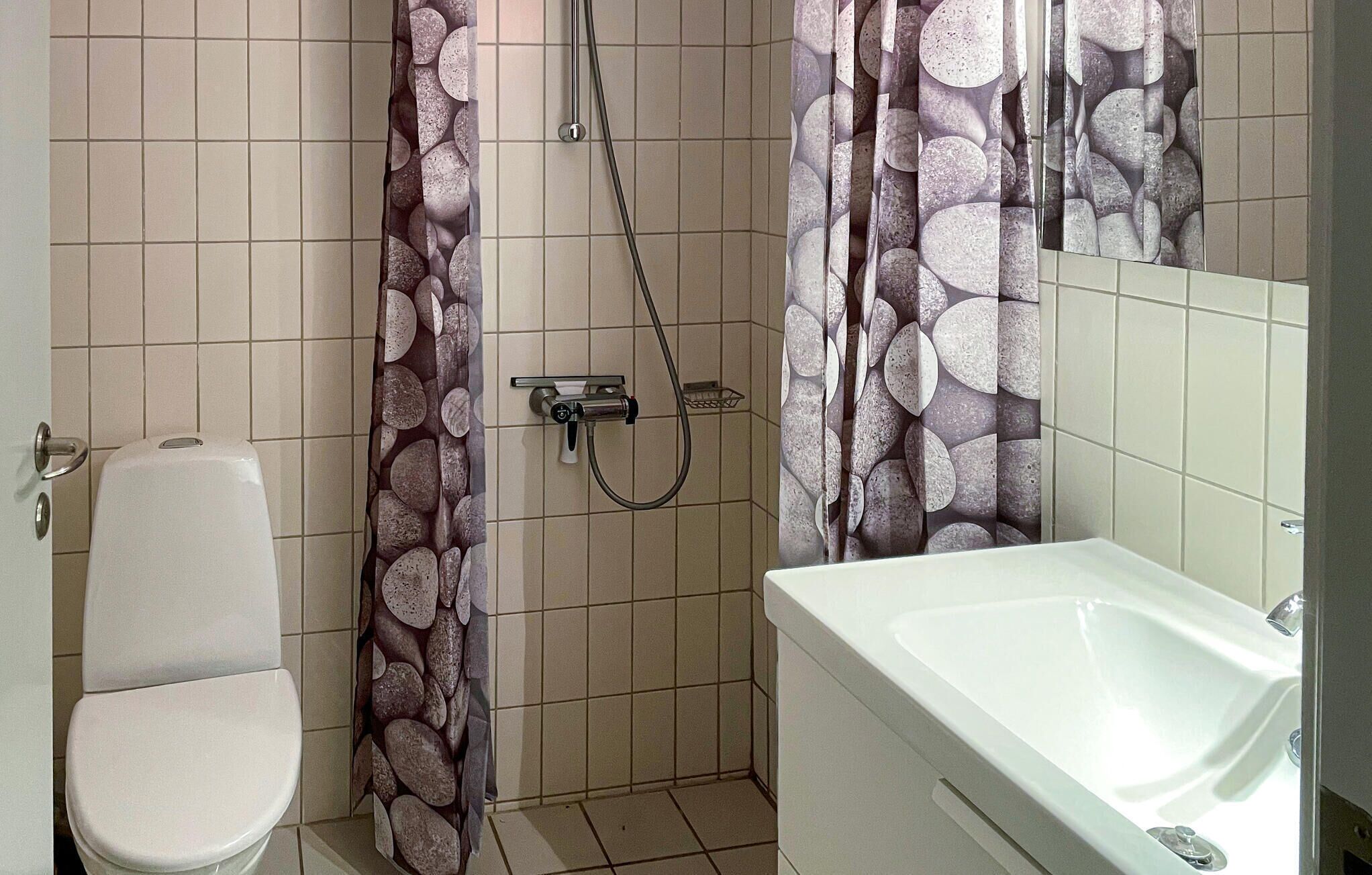 Une salle de bain équipée de toilettes, d’une douche et d’une baignoire.