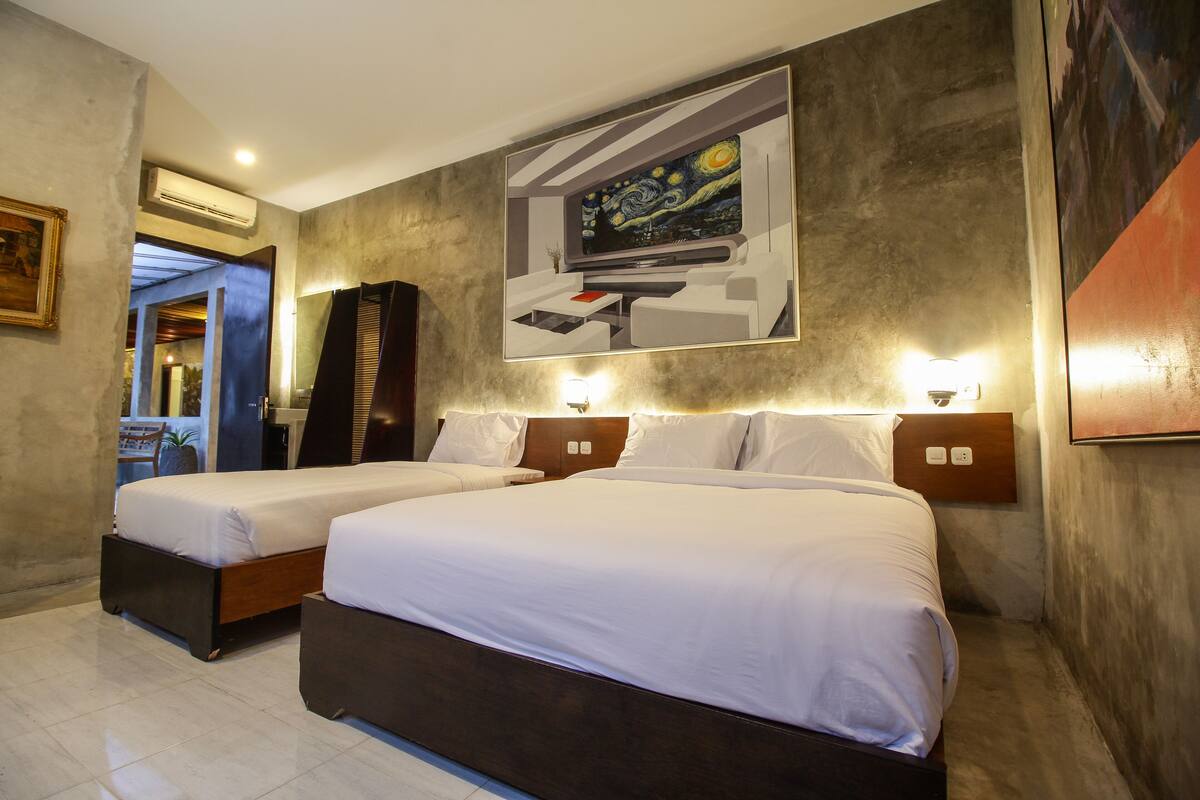 A hotel room with two beds, a large painting on the wall, and a modern design.