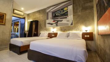 Habitación de hotel con dos camas, un cuadro grande en la pared y un diseño moderno.