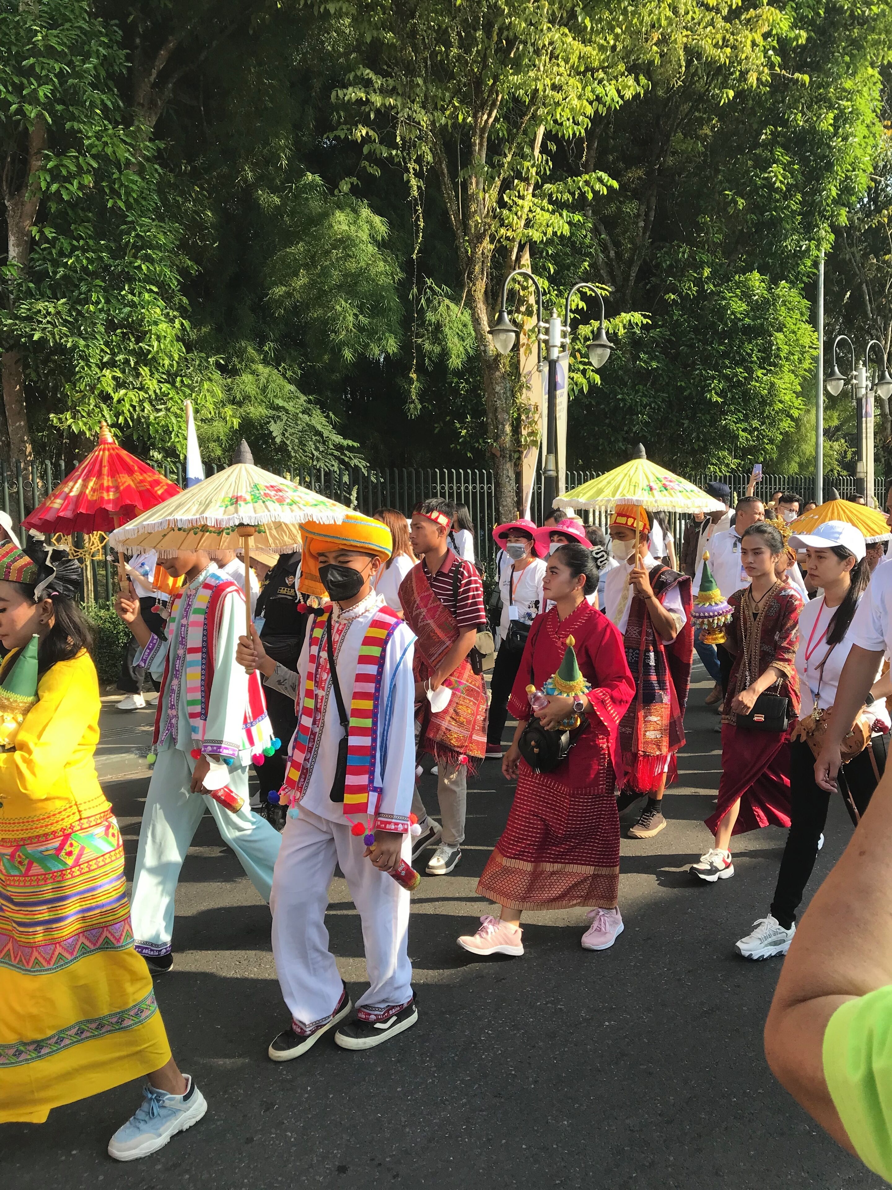 A group of people in traditional attire walking on a street.