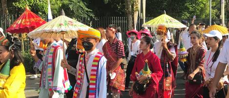 A group of people in traditional attire walking on a street.
