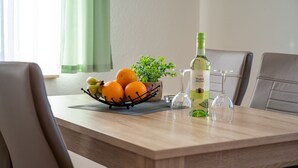 Ett matbord med en fruktskål, en flaska olivolja och ett glas.