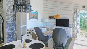 A modern living room with a round table, two grey armchairs, a sofa, a flat-screen TV, and a painting on the wall. - 2 bedroom lovely home in Kalmar (Kalmar)