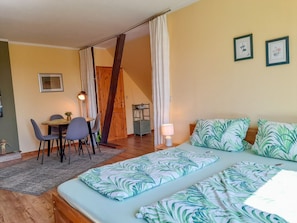 A room with a bed, a desk, and a chair. There are two framed pictures on the wall. - Vacation apartment 2 - Holiday apartments on the edge of the forest (Ahrenshagen-Daskow)
