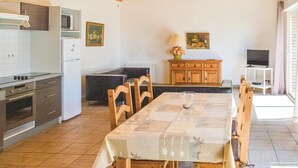 Eine kleine Küche mit Essbereich, Holzschränken und einem Fernseher.