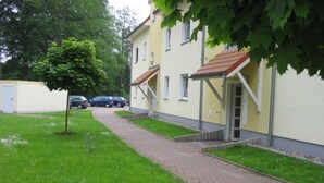 A pathway leading to a building with a tiled roof and a small tree in the foreground. - * FeWo Hansel GM 69372 - FeWo Hansel (Graal-Müritz)