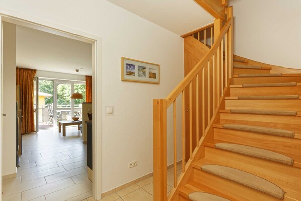 A staircase with wooden steps and a handrail, leading to an upper floor.
