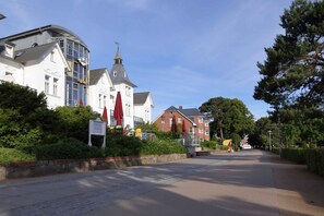 A street with buildings, including a church with a steeple and a sign that reads "Hotel." - Holiday home with terrace near the beach (Damp)
