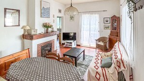 Ein gemütliches Wohnzimmer mit Kamin, Fernseher, einer Couch und einem Esstisch.