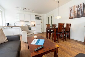 A modern apartment with a living room, dining area, and kitchen.