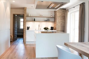 A modern kitchen with white cabinetry, wooden accents, and a central island.
