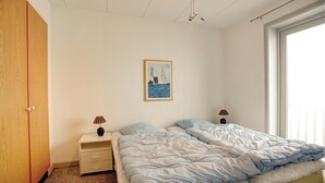 Una camera da letto con un letto, due comodini, un quadro e un armadio.