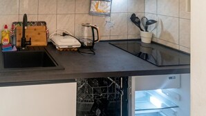 A kitchen with a sink, countertop, and a dishwasher.