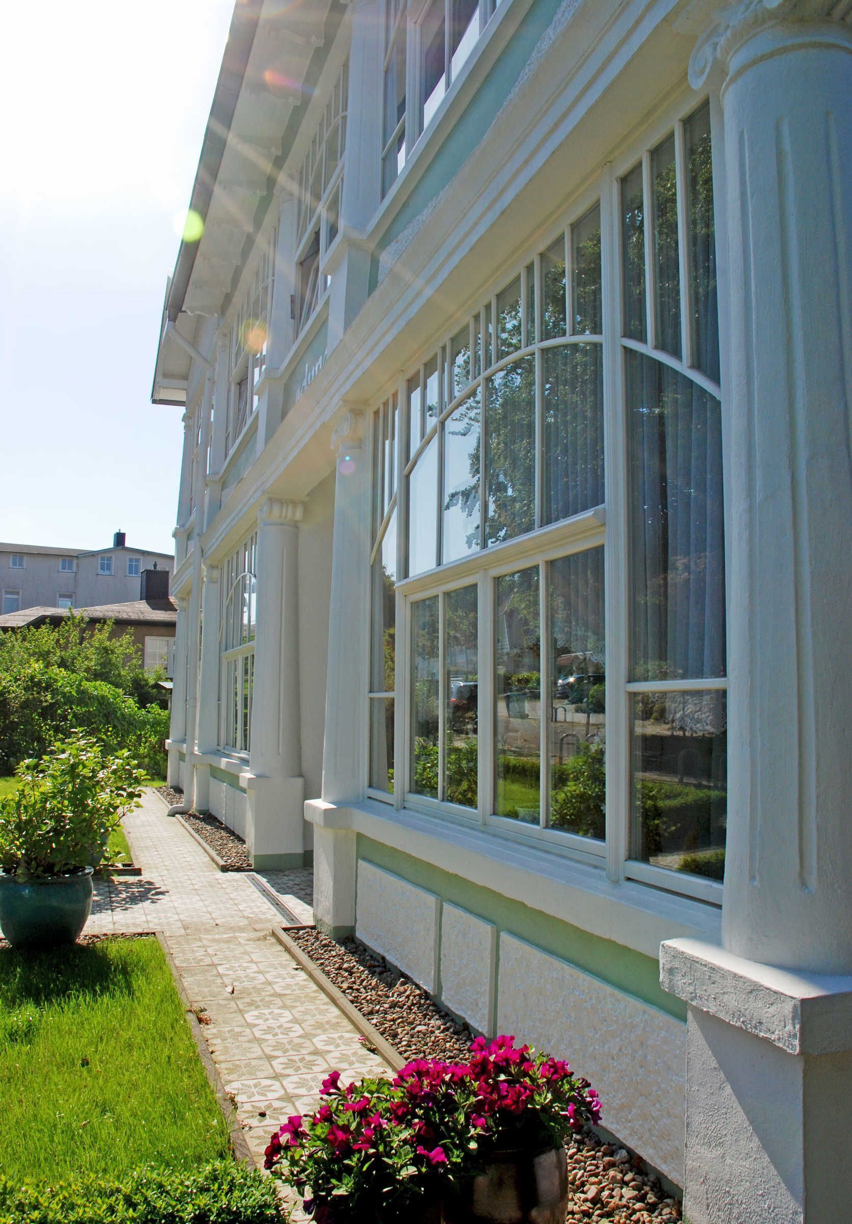 A building with large windows and a pathway leading to it.