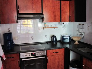 Een koelkast, een oven, een koffiezetapparaat/waterkoker, een waterkoker