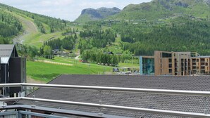 A mountainous landscape with a modern building featuring large windows and a flat roof. - Pet friendly apartment in Hemsedal (Hemsedal)