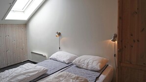 A bedroom with a skylight, a bed with white bedding, and a wooden wardrobe. - Pet friendly apartment in Hemsedal (Hemsedal)