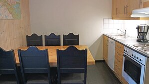 A compact kitchen with a wooden table and chairs, a coffee maker, and a dishwasher. - Pet friendly apartment in Hemsedal (Hemsedal)