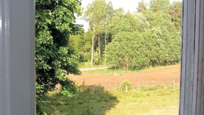 A view through a window of a rural landscape with trees and a fenced field. - 1 bedroom awesome home in Strömsnäsbruk (Strömsnäsbruk)