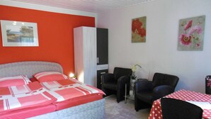 Une chambre à coucher comprenant un lit, une armoire, un bureau avec une chaise et une table avec une chaise.