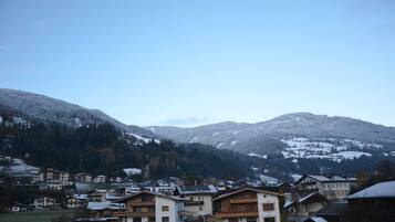 A residential area with buildings, a clear sky, and snow-covered mountains.