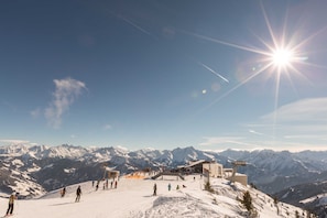 A snow-covered mountain slope with a ski lift and a building with a sloped roof. - Double room Hochzillertal 3 - Aparthotel **** AlpTirol (Kaltenbach)