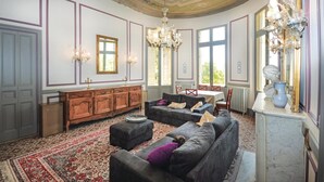 Ein geräumiges Wohnzimmer mit einer großen Couch, einem Holzschrank und einer Chandelüster.