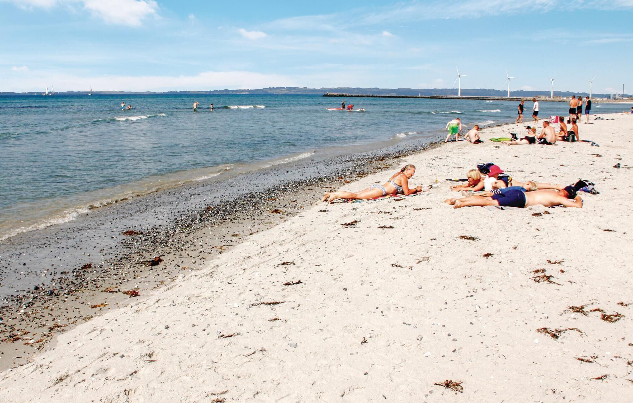 Ein Strand mit Menschen, die sonnenbaden und schwimmen.
