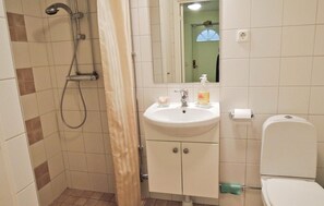 A bathroom with a shower, sink, toilet, and cabinets. - Nice home in Halmstad with kitchen (Halmstad)