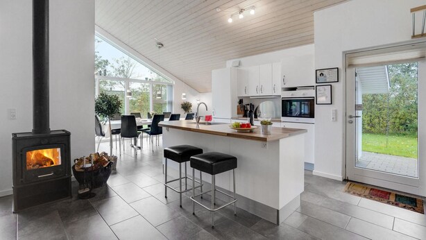 Una cucina moderna con un'isola centrale, piano cottura integrato e zona pranzo con sedie.
