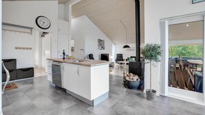 Una cucina moderna con un'isola centrale, un'area pranzo con tavolo in legno e un'ampia finestra vista all'esterno.