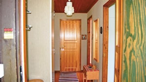 A hallway with wooden doors, a small table with a mug, and a striped rug. - 2 bedroom cozy home in Hamneda (Hamneda)