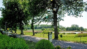 A landscaped area with pathways, trees, and a fenced field. - Double Room (11) - DEB 006 Pension Seeperle (Sellin)