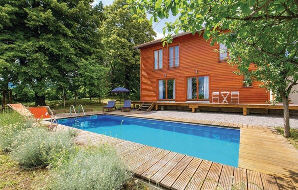 A wooden cabin with a swimming pool, deck, and outdoor seating. - Gorgeous home in Plaski with sauna (Plaski)