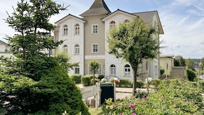 A building with a symmetrical facade, multiple windows, and a central tower. - MR: Villa Wilhelmine Whg. 02 Wilhelm with terrace - Villa Wilhelmine Whg. 02 (Sellin)