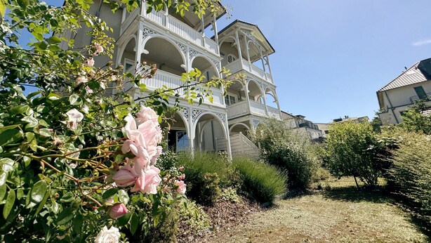 A two-story building with a balcony and a garden in front. - MR: Villa Wilhelmine Whg. 02 Wilhelm with terrace - Villa Wilhelmine Whg. 02 (Sellin)