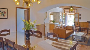 A dining area with a glass table, wooden chairs, and a vase of flowers. - Nice home in Pòrtol with kitchen (Pòrtol)