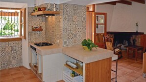 A compact kitchen with a gas stove, wooden shelves, and patterned tiles. - Nice home in Pòrtol with kitchen (Pòrtol)