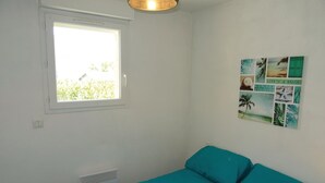 A room with a window, a wall-mounted light fixture, and a collage of beach-themed pictures. - Stunning home in Torreilles - Plage (Torreilles - Plage)