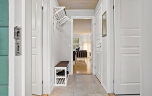 A hallway with white doors, a bench, and a shoe rack. - Gorgeous home in Nexø with WiFi (Nexø)