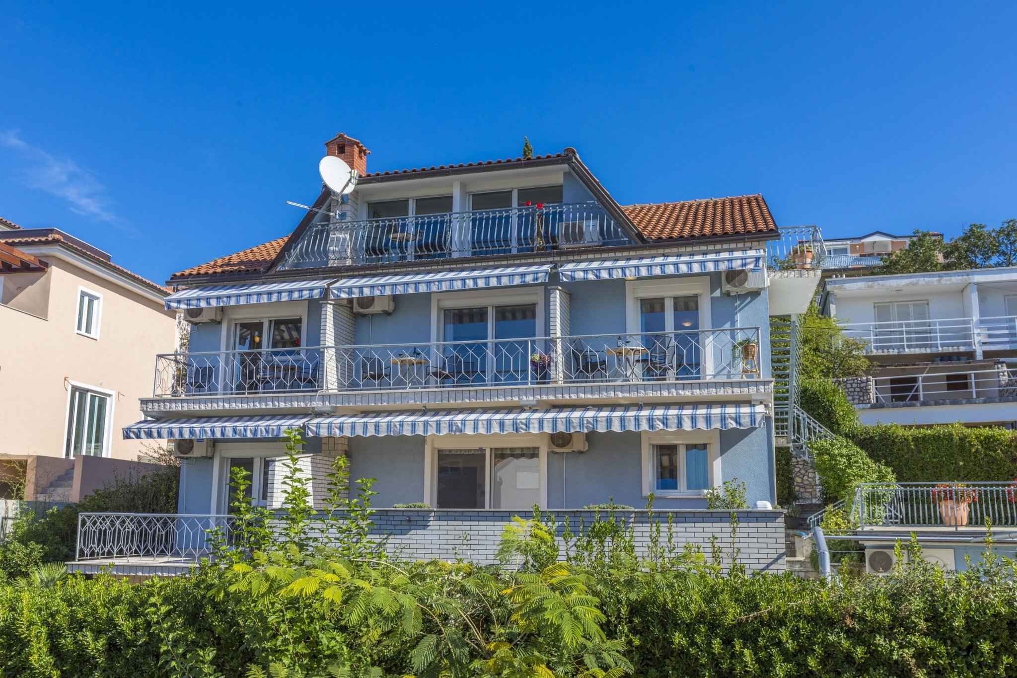 A two-story building with a balcony on the upper floor, a satellite dish, and a tiled roof.