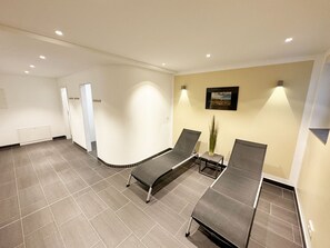 A modern waiting area with a reception desk, a reception area, and a seating area with two chairs and a table.