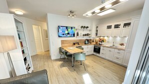 Eine moderne Küche mit weißen Schränken, einem Holzespeisetisch und einem eingebauten Backofen.