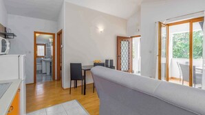 Um apartamento moderno com área de jantar, cozinha e varanda.