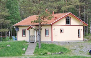 A single-story house with a red-tiled roof, a front porch, and a small garden area. - Lovely home in Hedekas with ethernet internet (Hedekas)