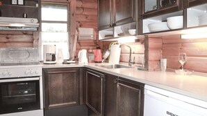 Una cocina con gabinetes de madera, estufa, fregadero y lavavajillas.